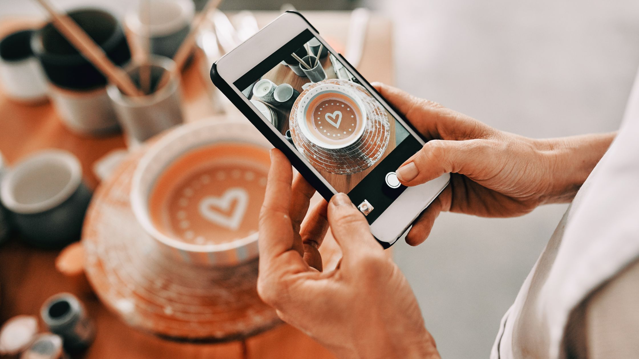 A photos of a woman taking picture of coffee for social media.